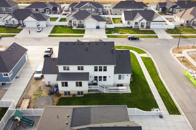 Aerial view of modern homes with green lawns in a suburban area of Spanish Fork, Utah.