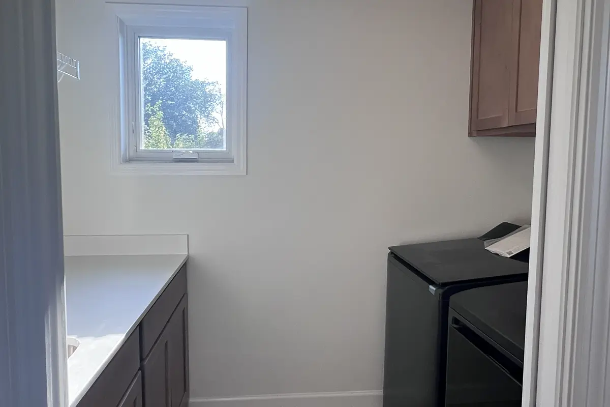 The Northstar 15 Laundry with black matte washer_dryer, cabinets, shelving, sink and window