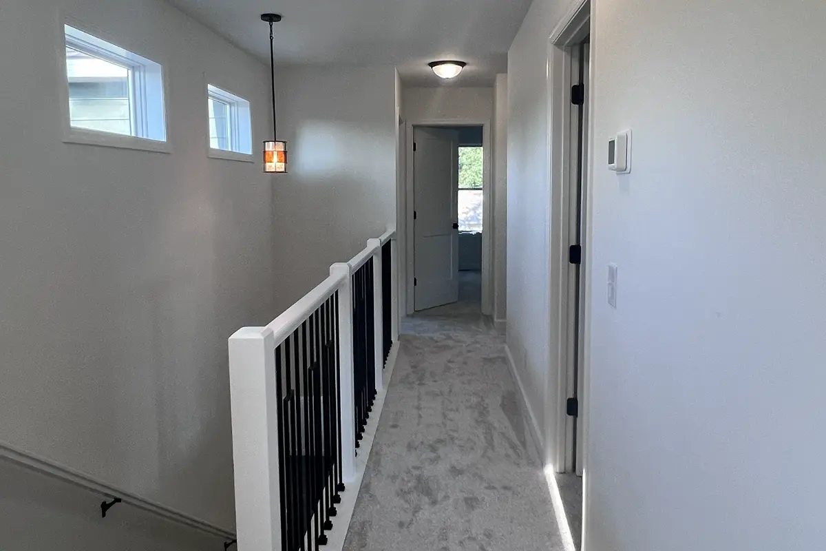 The Northstar 14 Upper level hall with banister and natural light from windows on left
