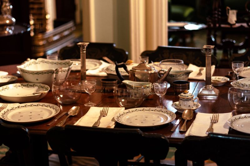 Elegant dining room with a beautifully set table, featuring fine china and silverware ready for a formal meal.