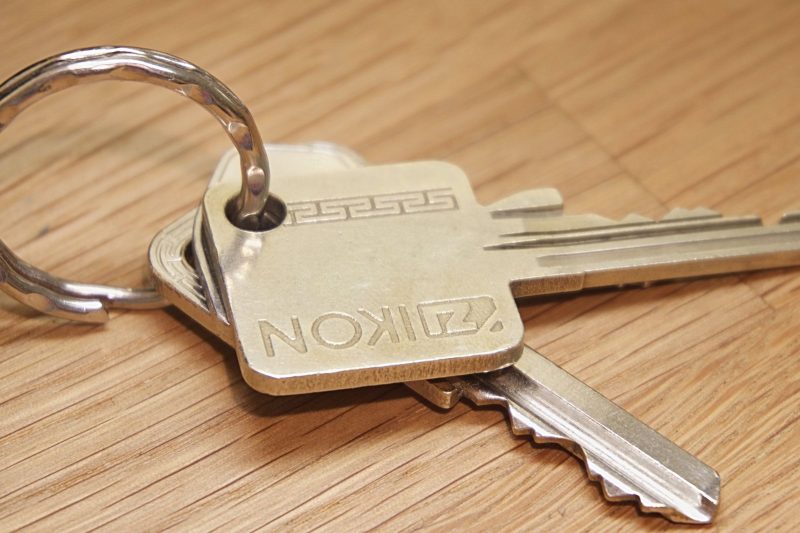 A set of metal house keys resting on a rustic wooden surface.