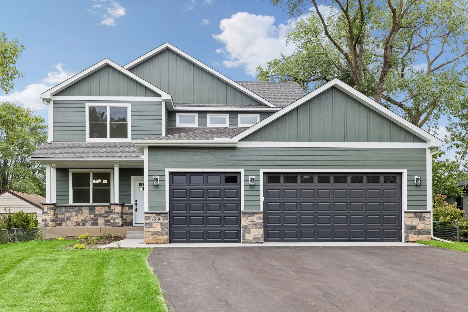Front view shows off front porch and 3-car garage
